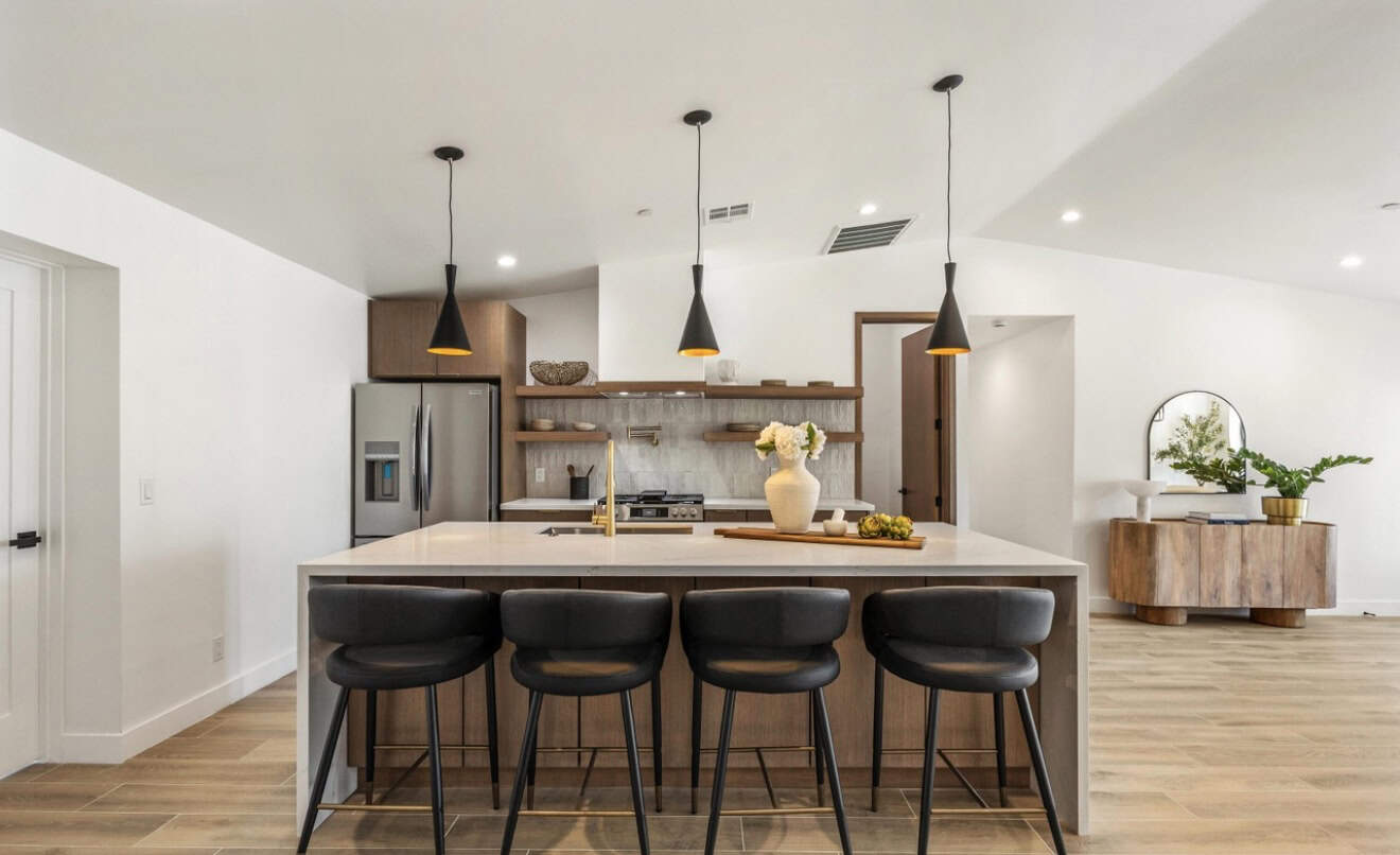 Modern kitchen with island, pendant lights, and sleek appliances.