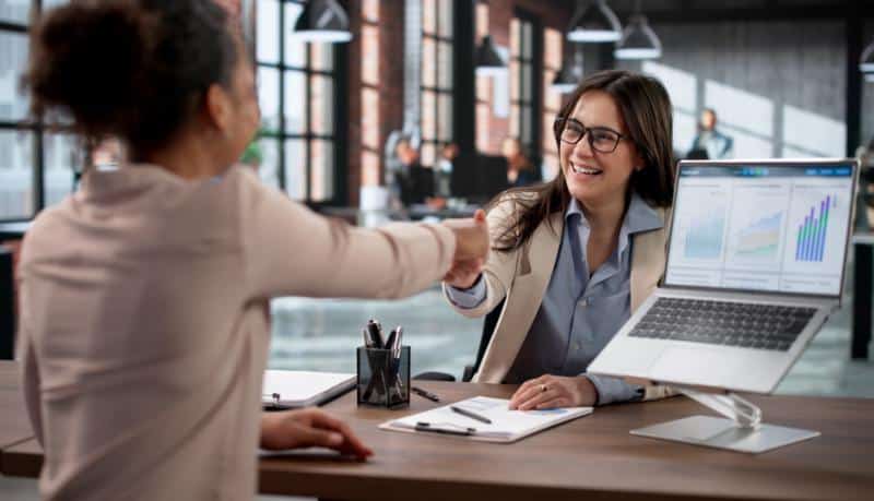 Businesswoman shaking hands during a meeting at Prolific Builders office.