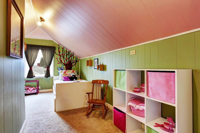 Attic bedroom featuring vibrant green walls, pink accents, and playful decor for a cheerful, invitin.