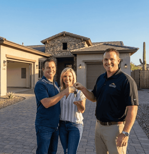 Happy homeowners receiving keys from Prolific Builders team outside new house.
