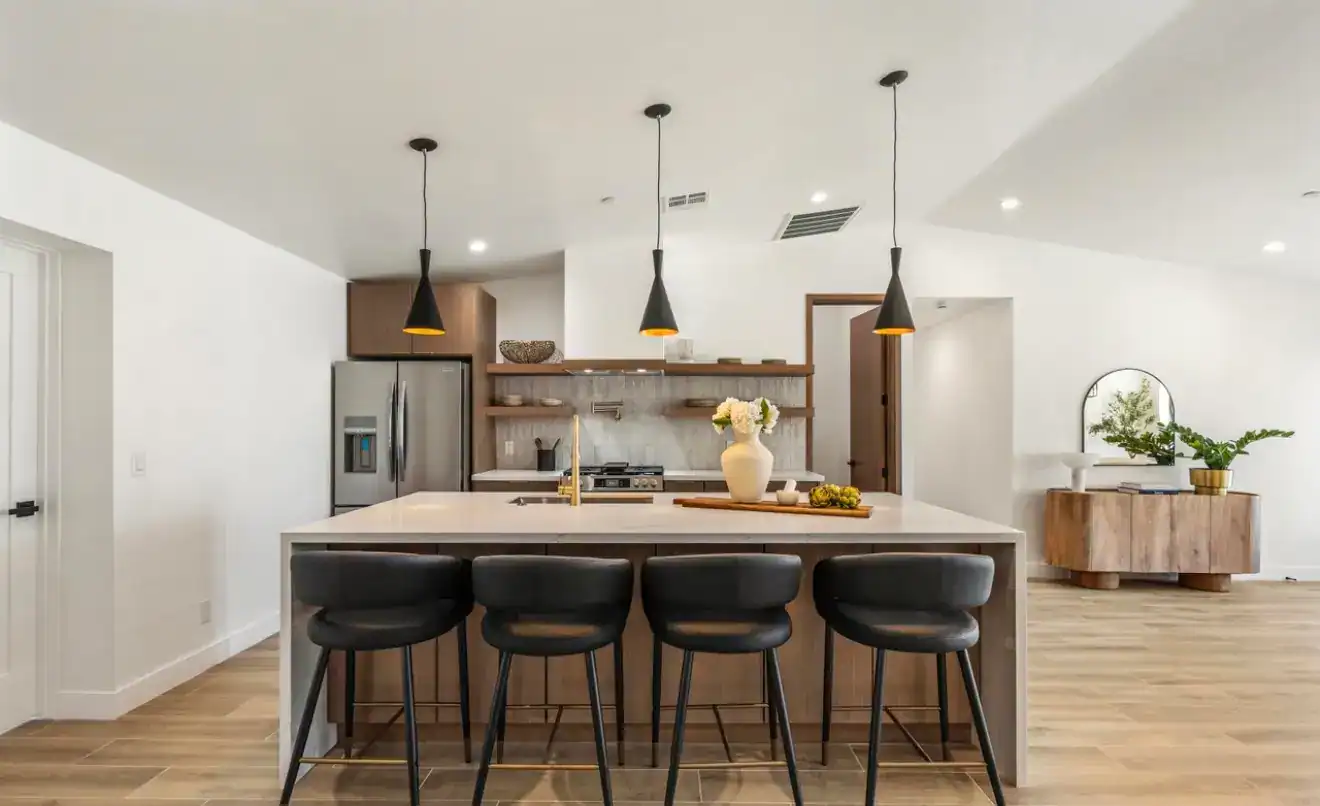 Kitchen with island, black stools, and contemporary decor, showcasing modern home interior design.